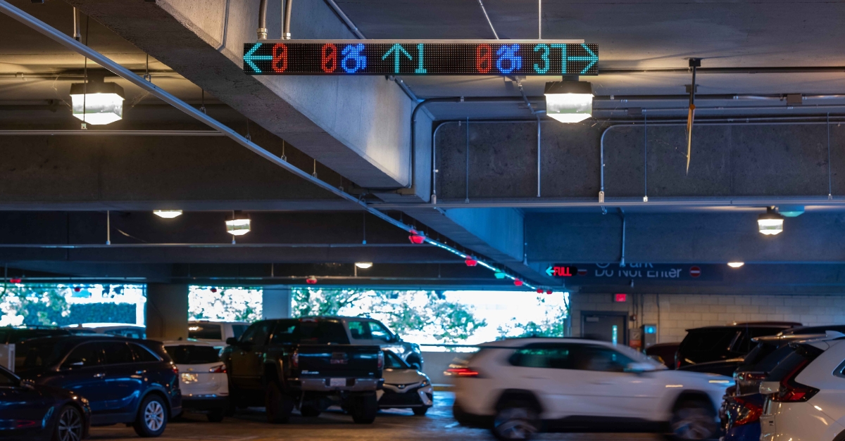 A car parking in a parking garage using parking guidance and VMS digital wayfinding signage